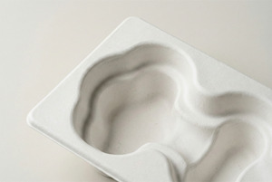Close-up of a premium wet-pressed molded pulp tray showing smooth surface and fine fibers.