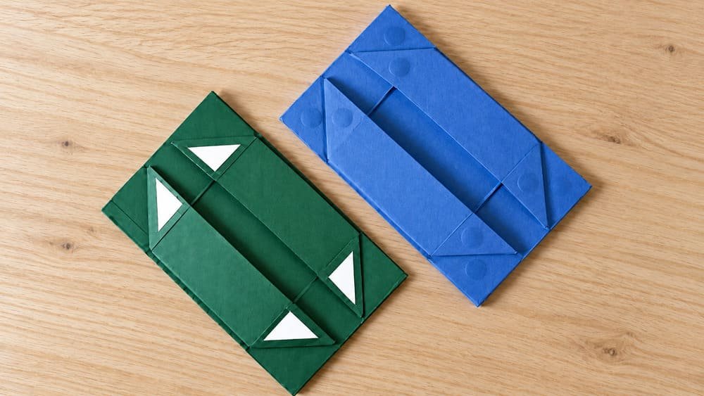 Klong 5-piece collapsible rigid box samples showing four triangular adhesive release liners and magnet-fixed inner box panels.

